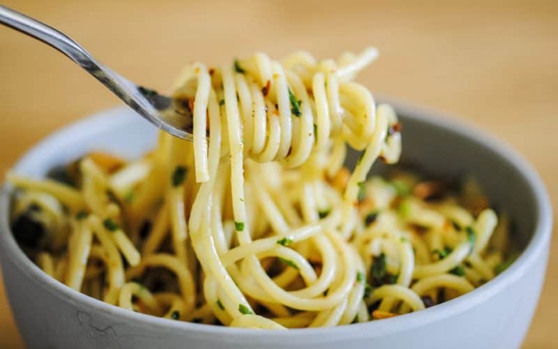 simple garlic basil pasta (spaghetti) wound around a fork