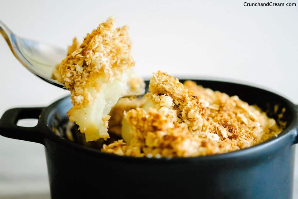 a spoonful of apple crumble with soft apples and a golden, crispy topping