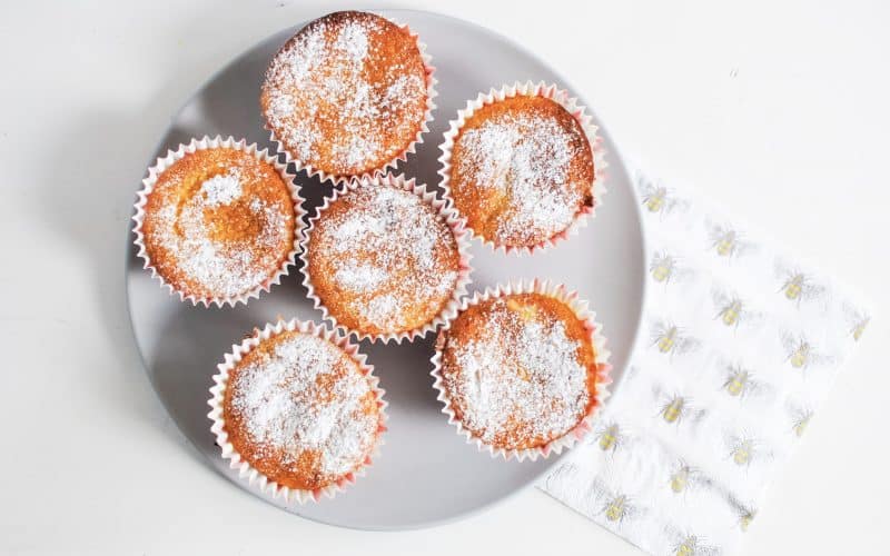 a plate of citrus olive oil cupcakes with a napkin to the side