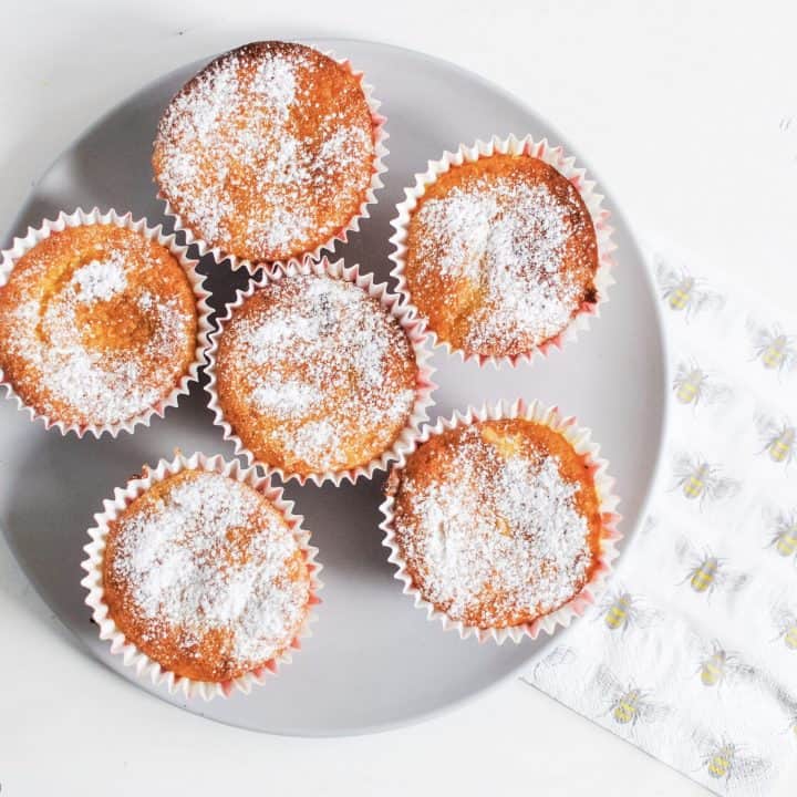 a plate of citrus olive oil cupcakes with a napkin to the side